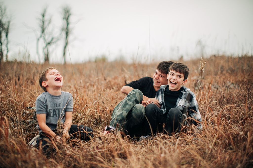 three boys enjoying their own company, teasing each other and laughing.