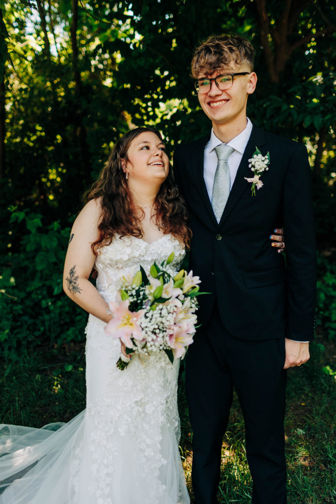 a bride and groom laugh while standing together