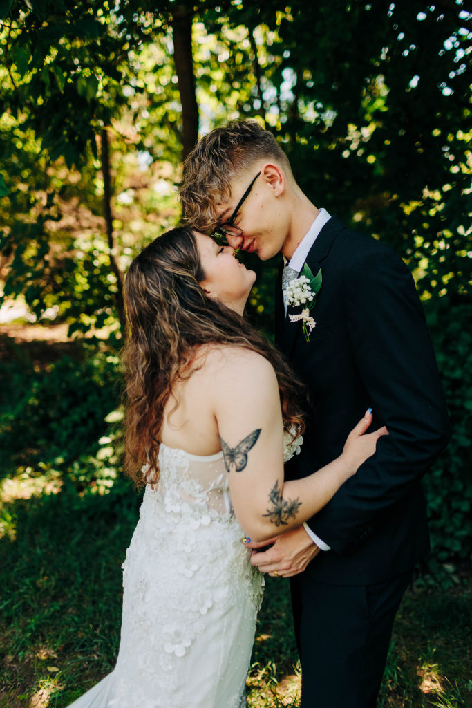 a bride and groom make goofy faces while rubbing noses