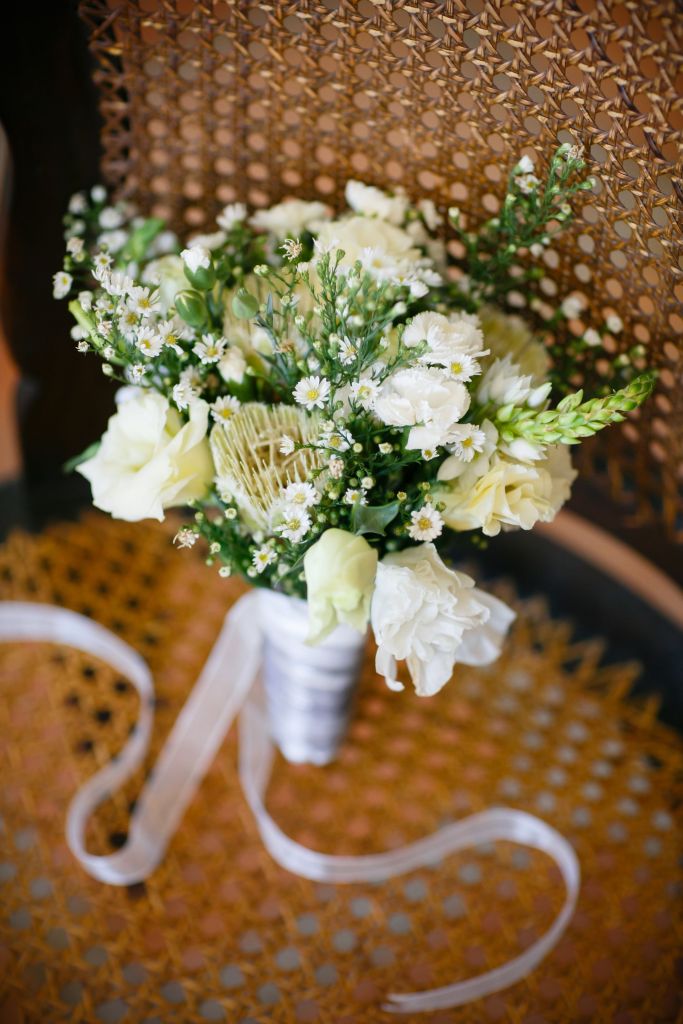 bride's beautiful bouquet rests against a wicker chair