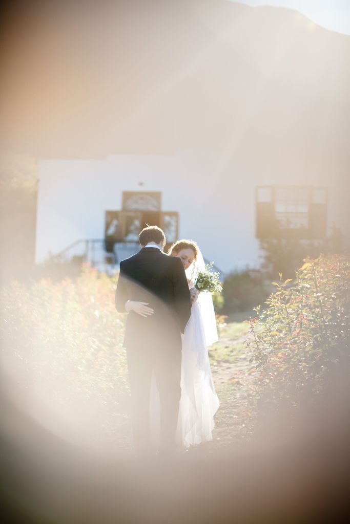 bride and groom have their "first look" in a rose garden